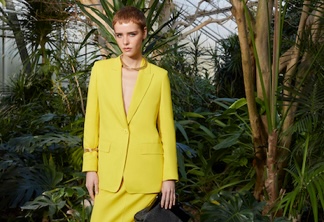 Modella indossa tailleur di colore giallo